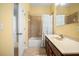 This is a yellow-toned bathroom with a shower and tub combo, a sink with a brown vanity, and a large mirror at 1810 Trophy Bass Way, Kissimmee, FL 34746