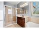 This bathroom features a tiled shower and tub and vanity with a decorative mirror and vanity lights at 1810 Trophy Bass Way, Kissimmee, FL 34746