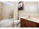 This bathroom features a shower and tub with a shower curtain and a dark vanity cabinet with a sink and mirror at 1810 Trophy Bass Way, Kissimmee, FL 34746