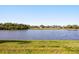 Peaceful lake view with lush green lawn in the foreground and houses on the opposite shore at 1810 Trophy Bass Way, Kissimmee, FL 34746