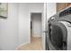 Neutral hallway with access to a laundry room with a gray washer and dryer at 1810 Trophy Bass Way, Kissimmee, FL 34746