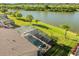 Aerial view of a screened-in pool and spa next to a serene lake, creating a private oasis at 1810 Trophy Bass Way, Kissimmee, FL 34746