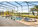 Stunning screened-in pool and spa overlooking a serene lake, surrounded by lush greenery at 1810 Trophy Bass Way, Kissimmee, FL 34746