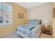 Guest bedroom featuring a bed with a colorful quilt, wooden flooring, and window shutters at 202 Longview Ave, Kissimmee, FL 34747