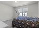 Neutral-toned bedroom with a floral-patterned comforter and window view at 2037 Canny Cv, Winter Park, FL 32792