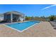 A view of the community pool with a seating area and landscaping at 2037 Canny Cv, Winter Park, FL 32792