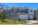 Two-story townhome featuring two-car garage, light grey exterior, and manicured lawn at 2037 Canny Cv, Winter Park, FL 32792