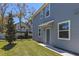 Side view of a light blue two-story townhome with green grass, a small tree, and a charming front door at 2037 Canny Cv, Winter Park, FL 32792