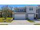 Two-story townhome featuring two-car garage, light grey exterior, and manicured lawn at 2037 Canny Cv, Winter Park, FL 32792