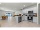 An open-concept kitchen with stainless steel appliances and a breakfast bar seamlessly connects to the living and dining areas at 2037 Canny Cv, Winter Park, FL 32792