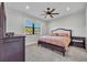 Cozy bedroom with a stylish bed frame, matching nightstands, and a large window offering natural light at 2072 Starboard Dr, Geneva, FL 32732