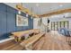 Farmhouse dining room featuring wooden table, bench seating, blue accent wall and a view to the outside at 2072 Starboard Dr, Geneva, FL 32732