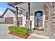 Inviting front entrance with stone pillars, decorative glass door, and a three car garage at 2072 Starboard Dr, Geneva, FL 32732