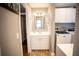 Bathroom featuring a white vanity and cabinets, a framed mirror, and a washer and dryer at 2211 Oberlin Ave, Orlando, FL 32804