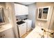 Bathroom featuring double sinks, a vanity with storage, and modern washer and dryer units at 2211 Oberlin Ave, Orlando, FL 32804