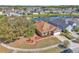 An aerial view of a brown roofed home with nearby pond and lush trees at 2215 Mallard Creek Cir, Kissimmee, FL 34743