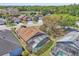 An aerial view of a brown roof home with a screened in lanai, lush trees, and nearby homes at 2215 Mallard Creek Cir, Kissimmee, FL 34743