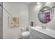 Bathroom with white vanity, round mirror and a shower with patterned curtain at 2215 Mallard Creek Cir, Kissimmee, FL 34743