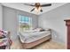 Bedroom featuring a full bed, window and a dark-toned ceiling fan at 2215 Mallard Creek Cir, Kissimmee, FL 34743