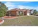 Beautiful single-story house featuring a well-maintained lawn, garden, and neutral-toned exterior at 2215 Mallard Creek Cir, Kissimmee, FL 34743