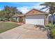 Charming single-story house features a well-manicured lawn, brick accents, and a two-car garage at 2215 Mallard Creek Cir, Kissimmee, FL 34743