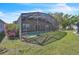 Outdoor screened pool with lush green grass and landscaped foliage at 2215 Mallard Creek Cir, Kissimmee, FL 34743