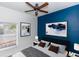 Stylish bedroom with a bold blue accent wall, modern furnishings, and plush bedding at 2217 Wekiva Reserve Blvd, Apopka, FL 32703