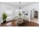 Bright dining room with wood floors, a round marble table, and arched doorway to the hallway at 2217 Wekiva Reserve Blvd, Apopka, FL 32703