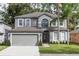 Charming two-story home featuring a gray exterior, two-car garage, and well-manicured lawn with palm trees at 2217 Wekiva Reserve Blvd, Apopka, FL 32703