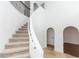 Bright foyer showcasing a curved staircase with neutral carpet and wrought iron railing, complemented by archways at 2217 Wekiva Reserve Blvd, Apopka, FL 32703