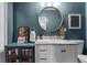 Charming bathroom with a white marble vanity, round mirror, and blue accent wall at 2424 Shrewsbury Rd, Orlando, FL 32803