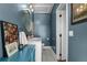 Well-lit bathroom with white tile floors and blue accent wall, featuring a marble vanity at 2424 Shrewsbury Rd, Orlando, FL 32803