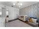 Bright Bedroom featuring patterned wallpaper, hardwood floors and a cozy gray chair at 2424 Shrewsbury Rd, Orlando, FL 32803