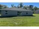 Back exterior view of home featuring windows and sliding glass door to backyard at 258 Fraser Rd, Debary, FL 32713