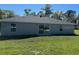 Back exterior view of home featuring windows and sliding glass door to backyard at 258 Fraser Rd, Debary, FL 32713