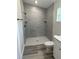 Modern bathroom showcasing a walk-in shower with gray tiling, a rainfall shower head, and black fixtures at 258 Fraser Rd, Debary, FL 32713