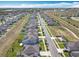 Aerial view showcasing a well-planned community with uniform homes, solar panels, and green spaces at 297 Citrus Isle Loop, Davenport, FL 33837