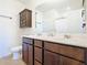 Bright bathroom with double sinks, dark wood cabinets, and large mirror at 297 Citrus Isle Loop, Davenport, FL 33837