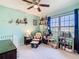 Cozy bedroom with a crib, rocking chair, and colorful decor, perfect for a Bedroom at 297 Citrus Isle Loop, Davenport, FL 33837