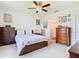 Comfortable bedroom with a ceiling fan and carpet floors with an ensuite bathroom at 297 Citrus Isle Loop, Davenport, FL 33837