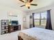 Comfortable bedroom with ceiling fan, neutral walls, large window, and wood furnishings at 297 Citrus Isle Loop, Davenport, FL 33837