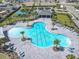 An aerial view showcases a bright blue pool featuring lounge chairs, palm trees and lap lanes at 297 Citrus Isle Loop, Davenport, FL 33837