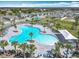 An aerial view showcases a bright blue community pool surrounded by sidewalks, lounge chairs and palm trees at 297 Citrus Isle Loop, Davenport, FL 33837