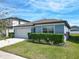 Attractive single-story home featuring a two-car garage and well-manicured front lawn with attractive landscaping at 297 Citrus Isle Loop, Davenport, FL 33837