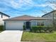 Charming single-story home features a manicured lawn, a two-car garage and lovely curb appeal at 297 Citrus Isle Loop, Davenport, FL 33837