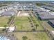 Aerial view of landscaped green space with palm trees and a walking path in a residential neighborhood at 297 Citrus Isle Loop, Davenport, FL 33837