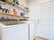 Well-organized laundry room with modern appliances and ample shelving for storage and detergents at 297 Citrus Isle Loop, Davenport, FL 33837