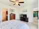 Bright main bedroom featuring a ceiling fan, an ensuite bathroom, and neutral color palette at 297 Citrus Isle Loop, Davenport, FL 33837