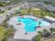 An aerial view of a community pool with many lounge chairs and palm trees, suitable for families at 297 Citrus Isle Loop, Davenport, FL 33837