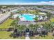 An aerial view of a refreshing community pool and clubhouse with lush greenery at 297 Citrus Isle Loop, Davenport, FL 33837